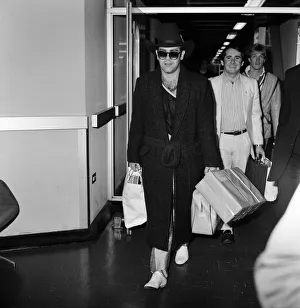 The arrival of Elton John at Heathrow Airport carrying Christmas presents from a buying
