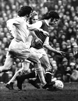Arsenal footballer Charlie George fights off 2 Bradford defenders as he makes an attack
