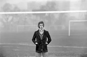 Arsenal footballer Charlie George walking amongst some local football pitches at Hackney