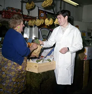 Customer Prints: Arsenal footballer Pat Rice serves a customer while working on his London fruit stall