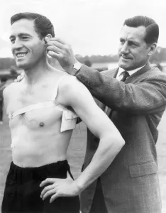 Arsenal manager George Swindin attaches a receiver to left back Jimmy Bloomfield to try