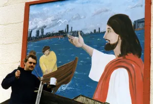 00507 Prints: Art student Gary McNamara with the mural he has painted above the entrance to St Pius