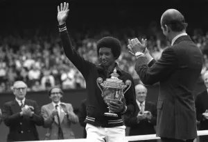 Arthur Ashe waves to fans after winning mens title in 1975 at Wimbledon with Duke of Kent