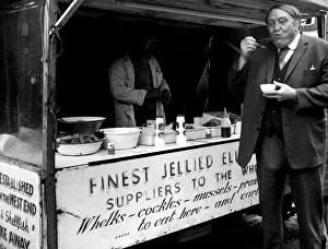 Stall Prints: Arthur Mullard enjoys some jellied eels in the West End December 1974
