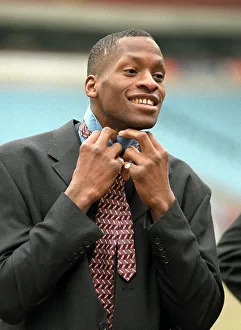 Aston Villa football player Ugo Ehiogu tying up his tie as he gets ready for the team