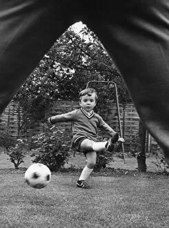 00325 Collection: Aston Villa footballer Ron Wylie playing football with his son Nigel in the garden of