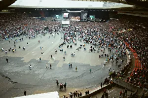 Audience gathered around the stage at Wembley where Michael Jackson can be seen