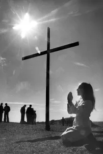 00083 Prints: Audrea Thompson prays by the cross mounted on Tunstall Hill, Sunderland in 1980