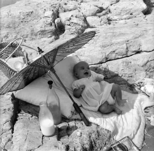 Baby under Sunshade beach pix. The happy baby is 4 months old Beverley Lovelock