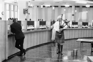 A bagpiper pipes the last day of business of 1970 in the Lloyds banking hall