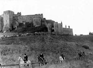 Hunter Prints: Bamburgh Castle made an impressive background as followers of the Percy Foxhounds moved