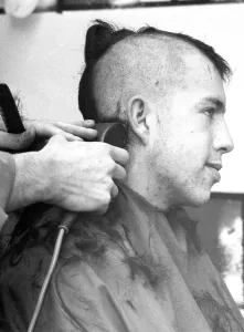 00107 Prints: A barber shaves nearly all the hair from this customers head to give him the new look
