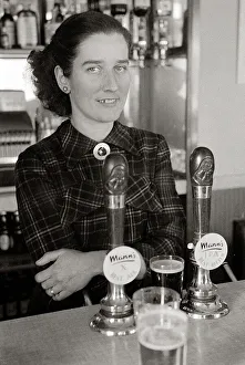 Pump Prints: The barmaid at The Chimes Lansbury Public House stands behind the bar beside the beer