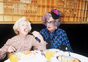 Barry Humphries as Dame Edna Everage glasses hat with Madge open mouth eating in La