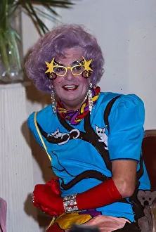 00104 Prints: Barry Humphries as Dame Edna Everage wearing blue dress red gloves