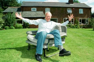 00353 Prints: Barry Norman Film Critic seen here in the garden of his Datchworth home with the chair he