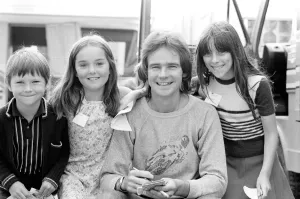 Barry Sheene signs autographs for three young children who broke through the security to