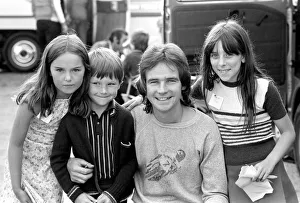 Barry Sheene signs autographs for three young children who broke through the security to
