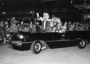 Outfit Prints: Batman and Robin escort Father Christmas safely into a city store as thousands of