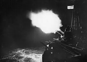 The battle ensign of HMS Mauritius crowning the night scene as the cruiser