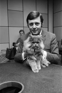 BBC commentator Michael Aspel at the BBC Studios at Lancaster Gate with a cat who is a