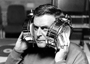 BBC radio disc jockey Terry Wogan pictured with large alarm clocks to his ears