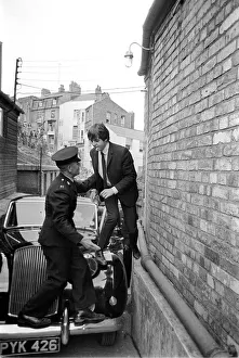 The Beatles August 1964 Paul McCartney is helped over his car by a guard to escape
