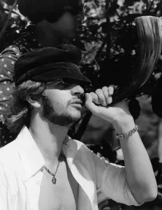Beatles drummer Ringo Starr blowing a horn while on holiday in Tobago, January 1966