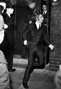 00596 Prints: Beatles drummer Ringo Starr bolts from a side exit to a waiting car after the band