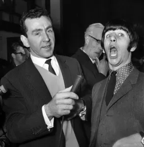Beatles drummer Ringo Starr shows off his tonsils to the press before entering
