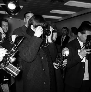 00109 Prints: The Beatles Leaving for New York. Ringo Starr taking pictures of Paul McCartney along