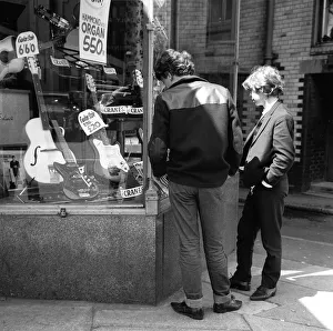 The Beatles May 1964 Young lads looking in the shop window at guitars for sale in