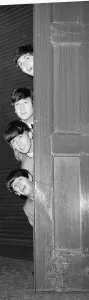The Beatles peering out from behind a door. before the groups appearence at Sunday Night