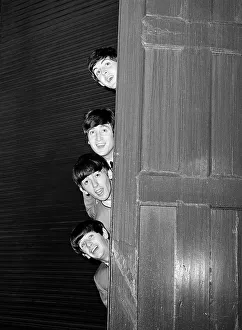 The Beatles peering out from behind a door. before the groups appearence at Sunday Night at the London Palladium, 13 October 1963. Top to bottom are: Paul McCartney, George Harrison, John Lennon, and Ringo Starr