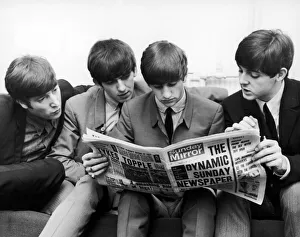 The Beatles, sit down to read the latest issue of The Sunday Mirror Newspaper