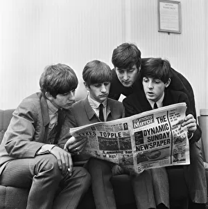 The Beatles, sit down to read the latest issue of The Sunday Mirror Newspaper