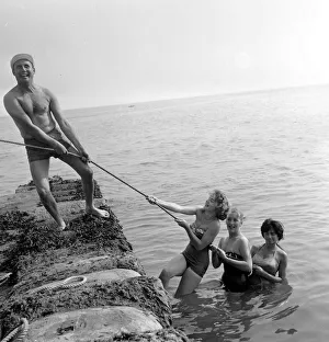00082 Prints: Beauty contest contestant seen here playing a game of tug of war with the shows compaere