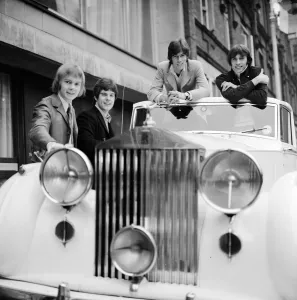 The Bee Gees examine an early christmas present from agent Robert Stigwood