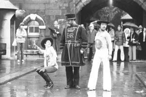 Disco Prints: Beefeater Rory Crozier looks on in disbelief as disco dancers Lucia Catti (18