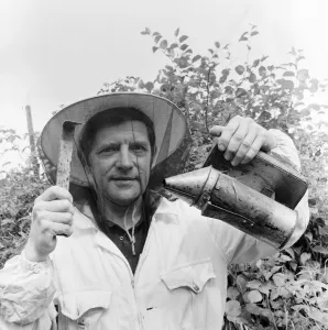 01015 Prints: Beekeeper, G Baitey, holding Smoker with heat shield and hook, Newcastle, 22nd July 1971