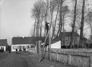 Ladders Prints: Belgian army telephone engineer seen here repair the phone lines to the armys