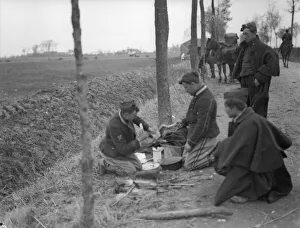 00117 Prints: Belgian soldiers seen here preparing a chicken for the pot during a respite in the recent