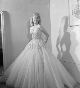 01202 Prints: Belinda Lee, British actress tries on dress designed by Julie Harris