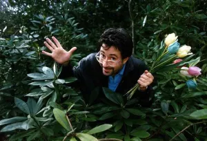 Tulips Prints: Ben Elton comedian writer actor standing in between plants holding a bunch of Tulips