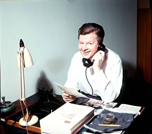 Benny Hill comedian sitting at a desk in his Kensington flat