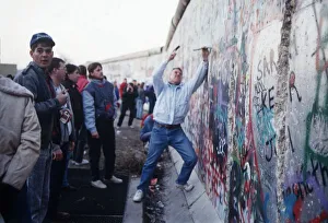 Berlin Wall souvenir hunter chip at the wall for memorabilia before it is demolished