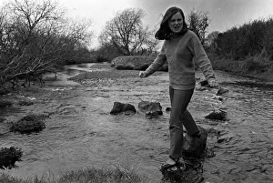 00007 Prints: Bernadette Devlin MP for Mid Ulster walking on stepping stones across a river