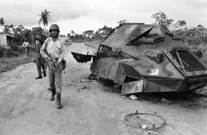 African Prints: A Biafran soldier seen here beside a destroyed Nigerian army armoured personnel carrier