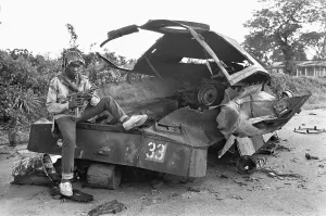 00892 Prints: A Biafran soldier seen here sitting on a destroyed Nigerian army armoured personnel