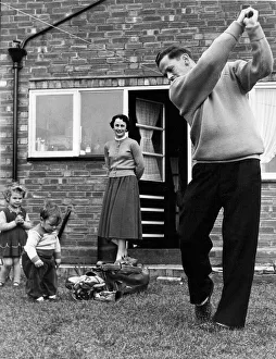 Birmingham City footballer Gordon Astall practices his golf swing at home in his back